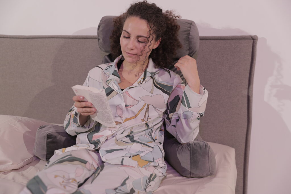 femme lisant un livre appuyée sur un coussin de lecture