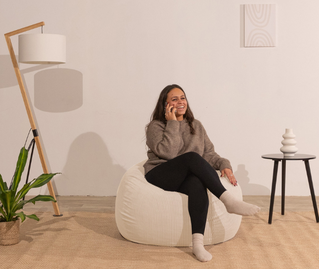 femme assise sur pouf poire beige