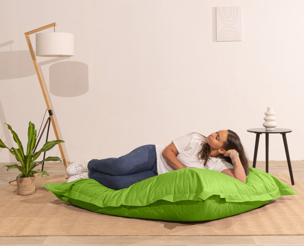 pouf extérieur vert avec femme allongée dessus