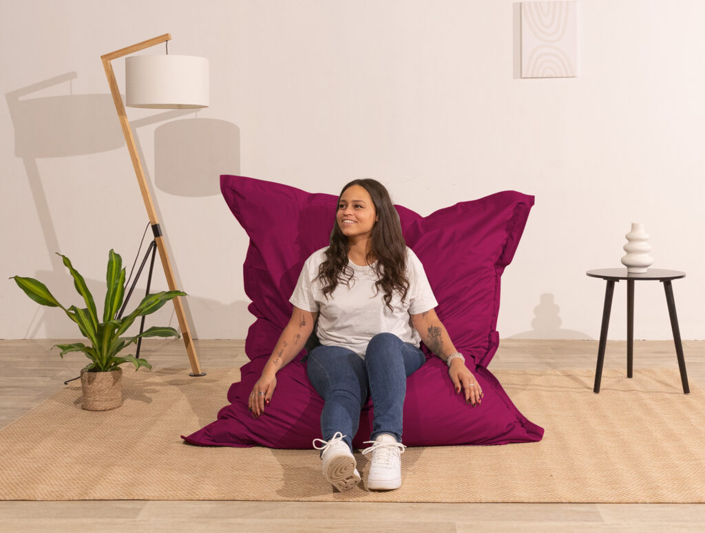 fille assise sur pouf extérieur rouge