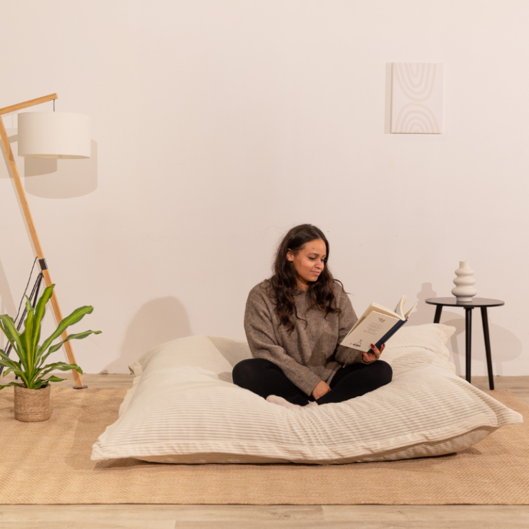 pouf XXL avec fille assise dessus en lisant un livre